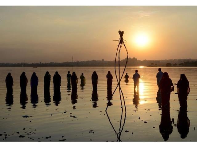Indian Hindu devotees offer prayers to the sun during the Chhath festival on the banks of the Hussain Sagar Lake in Hyderabad. (Noah Seelam/AFP Photo )