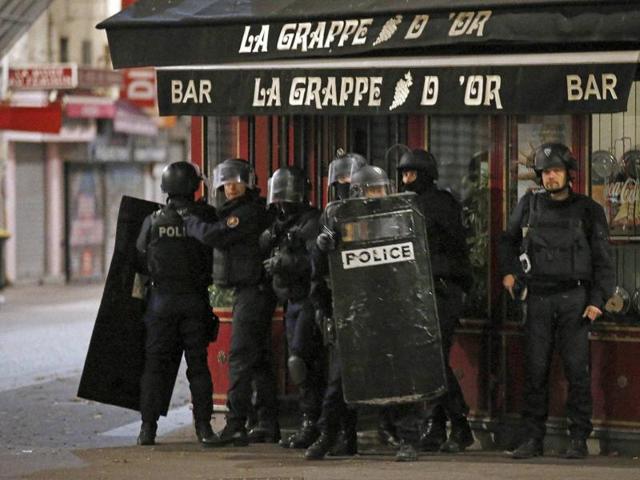 Policemen and firefighters are pictured in the northern Paris suburb of Saint-Denis city centre, on November 18, 2015, as French Police special forces raid an apartment, hunting those behind the attacks that claimed 129 lives in the French capital five days ago.(AFP)