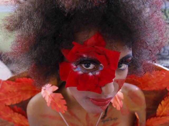 Ulia Matos in bright shades of red and orange poses for the camera during the school of theatre, makeup and hair styling graduation contest in Havana. (REUTERS)