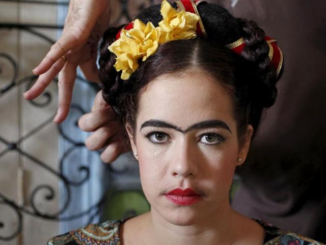 A student Andrea Doimeadios, representing Mexican painter Frida Kahlo, gets ready to perform in a school of theatre, makeup and hair styling graduation contest in Havana, Cuba on November 16, 2015. (REUTERS)