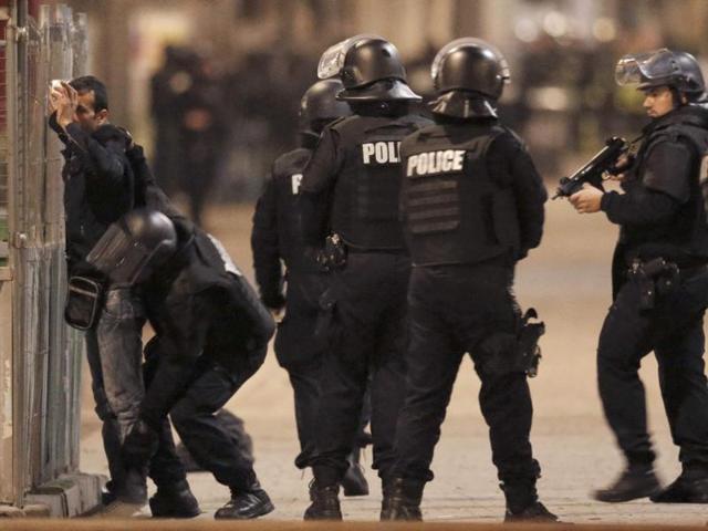 French spolice stop and search a local resident as shots are exchanged in Saint-Denis, France, near Paris, during an operation to catch fugitives from Friday night's deadly attacks in the French capital. (REUTERS Photo)