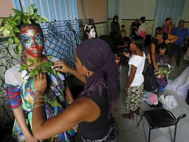 With her face painted in bold colours and with leaves as embellishment, Cesia Gonzalez (L) prepares to participate in a school of theatre, makeup and hair styling graduation contest in Havana. (REUTERS)