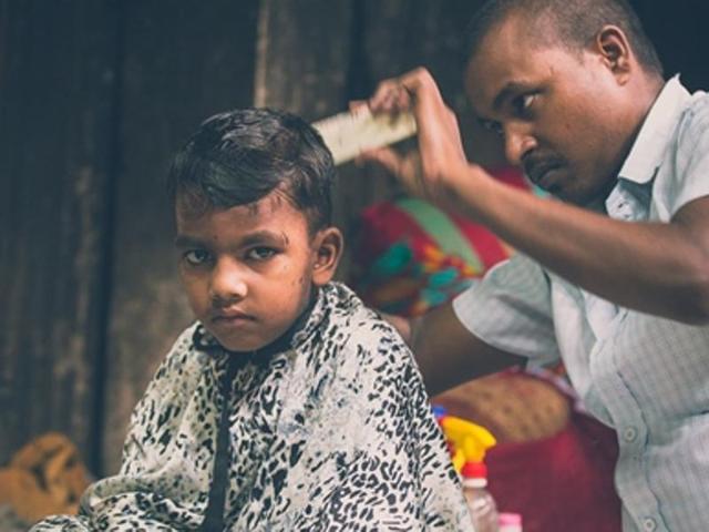 Community living: Despite the lack of space, Dhobi Ghat contains a self sustaining ecosystem. Here we see a young boy getting a routine haircut (Photo: Vipul Prasad) 