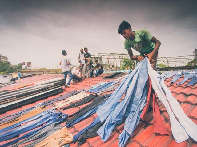 Sorting through the laundry: A worker picks up the dried clothes for sorting and ironing (Photo: Vipul Prasad) 