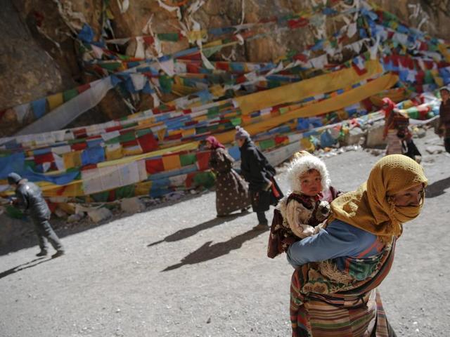 A Tibetan woman carries a child as they visit Namtso lake. Itis not only the highest saltwater lake in the world but also considered sacred, attracting throngs of devotees and pilgrims. (REUTERS)