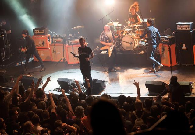 A picture taken on November 13, 2015 shows American rock group Eagles of Death Metal performing on stage at the Bataclan concert hall in Paris, a few moments before men armed with assault rifles stormed into the venue. (AFP Photo)