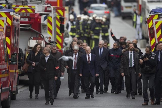 French interior minister Bernard Cazeneuve, center, arrives in Saint-Denis, near Paris, where a woman wearing an explosive suicide vest blew herself up as heavily armed police tried to storm an apartment where the suspected mastermind of last week's attacks was believed to be holed up, police said. (AP) French interior minister Bernard Cazeneuve, center, arrives in Saint-Denis, near Paris, where a woman wearing an explosive suicide vest blew herself up as heavily armed police tried to storm an apartment where the suspected mastermind of last week's attacks was believed to be holed up, police said. (AP)