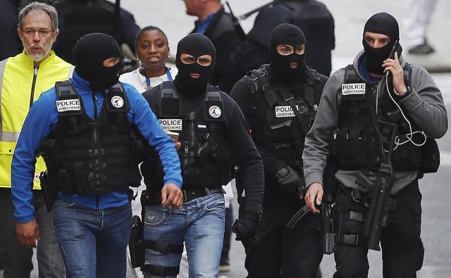 Hooded police officers walk in a street of Saint-Denis. (AP) Hooded police officers walk in a street of Saint-Denis. (AP)