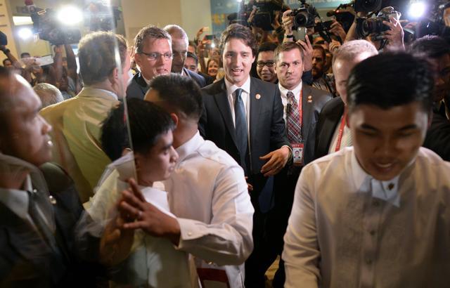 Canada's Prime Minister Justin Trudeau (C) is surrounded by press and volunteers as he leaves after a press conference at the Asia-Pacific Economic Cooperation (APEC) Summit in Manila (AFP) Canada's Prime Minister Justin Trudeau (C) is surrounded by press and volunteers as he leaves after a press conference at the Asia-Pacific Economic Cooperation (APEC) Summit in Manila (AFP)