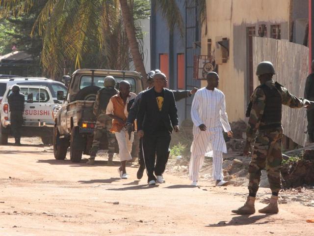 Security force personnel escort people fleeing from the Radisson Blu Hotel in Bamako, Mali. The company that runs the Radisson Blu Hotel in Mali's capital said assailants have taken hostages in a brazen assault involving grenades. (AP)