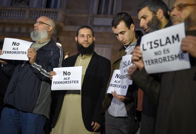 People show posters reading "No to terrorists" and "Islam is not terrorism" during a demonstration, called by the IBN Battuta Foundation on behalf of the Muslim community, on Plaza Sant Jaume in Barcelona. (AFP)