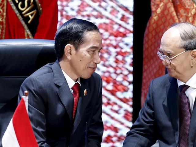 Indonesia's President Joko Widodo (L) and Myanmar's President Thein Sein talk before a Signing Ceremony Against Trafficking in Persons at the ASEAN Summit . (REUTERS)