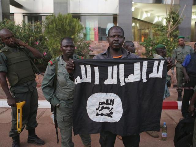 Malian security officials show a flag they said belonged to attackers in front of the Radisson hotel in Bamako, Mali. (REUTERS) Malian security officials show a flag they said belonged to attackers in front of the Radisson hotel in Bamako, Mali. (REUTERS)