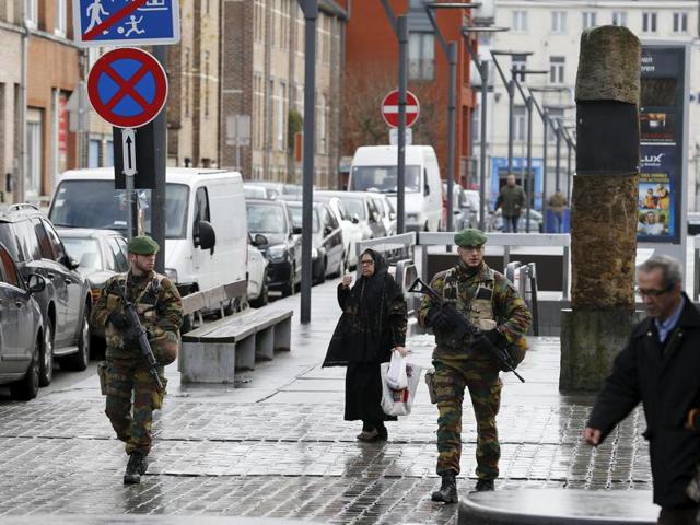 A police officer and a soldier patrol on the Anspach boulevard on November 22, 2015 in Brussels. Security was tightened in Belgium with the capital on maximum alert following the fatal attacks in Paris. (AFP)