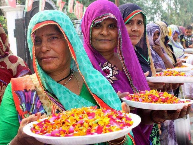 Village women wait to welcome SP chief Mulayam Singh Yadav on his 77th birthday in Saifai on Saturday. (PTI Photo)