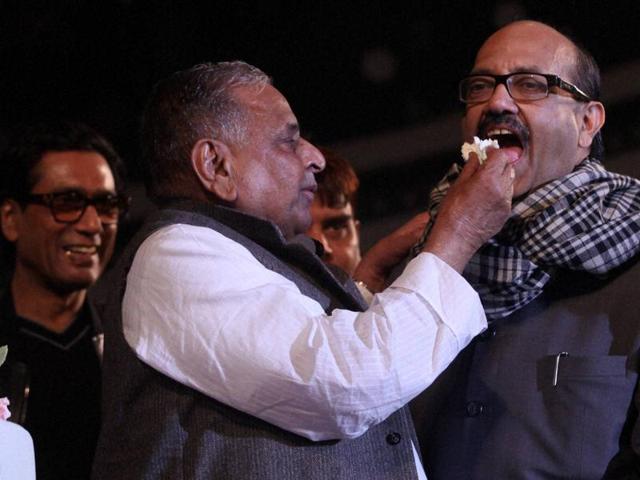 Samajwadi Party supremo Mulayam Singh Yadav feeds Amar Singh cake at his 77th birthday celebration in Saifai on Saturday. (PTI Photo)