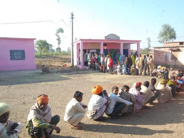 Voters line up at a polling booth at Unnai village in Jhabua district on Saturday.(HT photo)