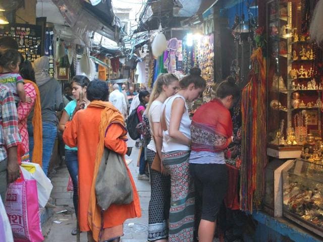 Foreign tourists in a lane near the Kashi Vishwanath temple in Varanasi. The trust of the temple has issued an order asking foreign tourists in short dresses to wear a sari or dhoti and ‘anga vastram’ before entering the sanctum sanctorum.(HT file photo)