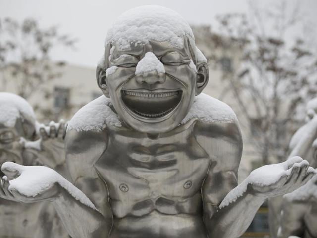 A part of a sculpture by Chinese artist Yue Minjun is covered by snow in central Beijing, China, November 22, 2015. Minjun is best known for depicting himself frozen in laughter in various settings across media. (REUTERS) A part of a sculpture by Chinese artist Yue Minjun is covered by snow in central Beijing, China, November 22, 2015. Minjun is best known for depicting himself frozen in laughter in various settings across media. (REUTERS)