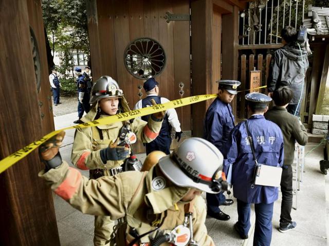 Police officers and fire fighters investigate at the south gate of Japan's controversial Yasukuni Shrine where there was an explosion and burned the ceiling and wall of the public bathroom, in Tokyo, Japan. (REUTERS) Police officers and fire fighters investigate at the south gate of Japan's controversial Yasukuni Shrine where there was an explosion and burned the ceiling and wall of the public bathroom, in Tokyo, Japan. (REUTERS)