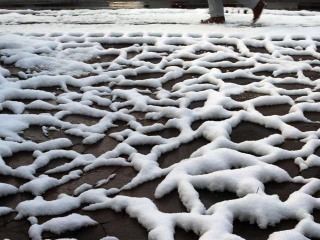 A man walks past snow forming a graphic pattern between the slabs on the pavement on November 22, 2015 in Kaufbeuren, southern Germany, after first snow of the season fell in the region. (AFP) A man walks past snow forming a graphic pattern between the slabs on the pavement on November 22, 2015 in Kaufbeuren, southern Germany, after first snow of the season fell in the region. (AFP)