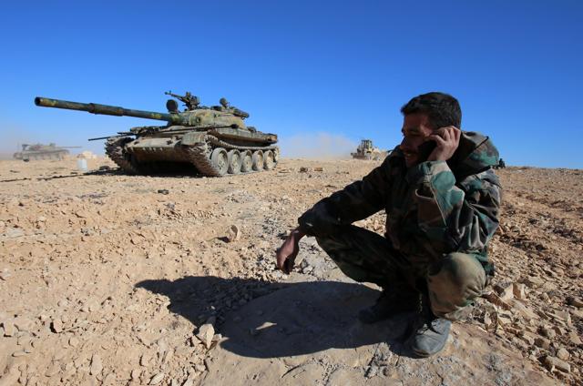 A member of the Syrian pro-government forces speaks on a mobile phone as troops gather on a hilltop they reported took over overlooking the town of Mahin, which is under control of the Islamic State group. (AFP) A member of the Syrian pro-government forces speaks on a mobile phone as troops gather on a hilltop they reported took over overlooking the town of Mahin, which is under control of the Islamic State group. (AFP)