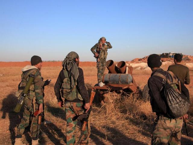 A group of Syrian pro-government forces inspect a home-made rocket launcher during a military operation against the Islamic State group in the east of the northern Syrian province of Aleppo.(AFP)