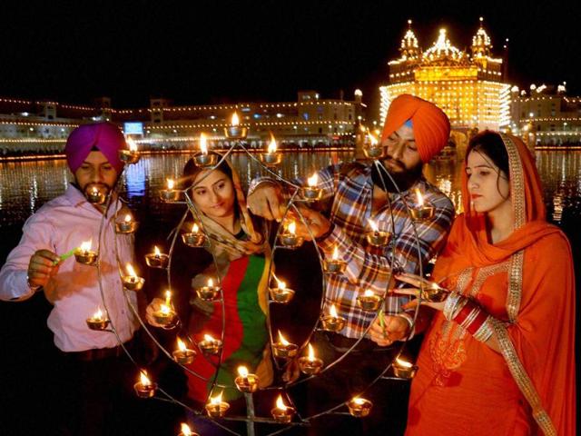 Devotees illuminate candles at the Golden Temple on the occasion of the 547th birth anniversary of Guru Nanak Dev, in Amritsar. (PTI Photo) Devotees illuminate candles at the Golden Temple on the occasion of the 547th birth anniversary of Guru Nanak Dev, in Amritsar. (PTI Photo)