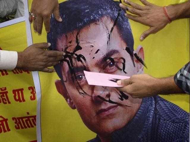 BJP activists paint a poster of Bollywood actor Aamir Khan with black color as they protest over actor’s intolerance remark, in Patna, Bihar on Tuesday, November 24, 2015. (Photo by Santosh Kumar/ Hindustan Times)