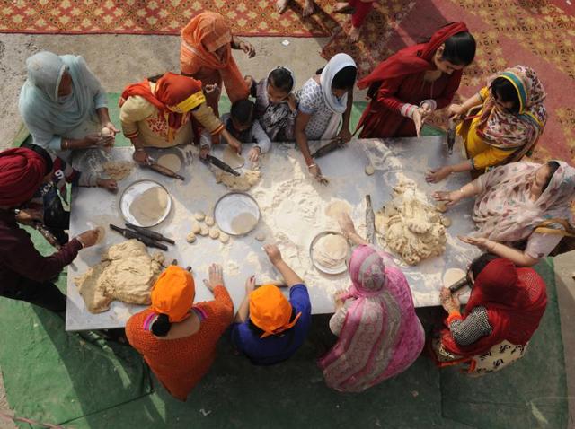 Sikh devotees prepare langar, a community meal, to serve other devotees in a gurudwara.  (Burhaan Kinu/HT Photo) 