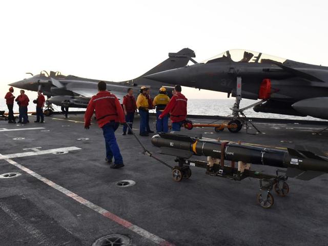 French navy engineers install a missile on a French Rafale fighter aircraft aboard the French Charles-de-Gaulle aircraft carrier at the eastern Mediterranean sea.(AFP)