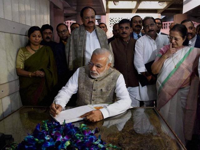 Prime Minister Narendra Modi signs the visitor's book after the inauguration of an exhibition on making of the Constitution by the Constituent Assembly, at Parliament Library in New Delhi. (PTI)