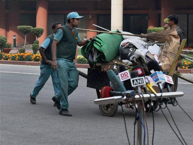 Cleaners carrying the garbage on the first day of the winter session of Parliament. (PTI)