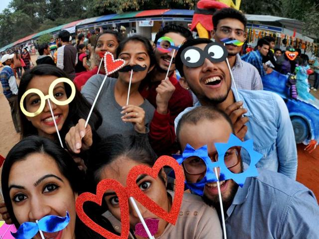 Youngsters having a little fun with colourful photo props during at the Chandigarh Carnival. (Ravi Kumar/HT )
