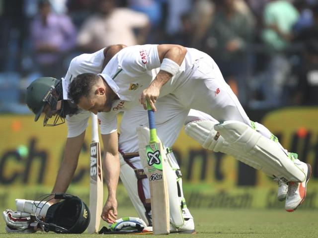 Hashim Amla, left, and Faf du Plessis, pick up their gear as they enter the field after lunch. (AP Photo)