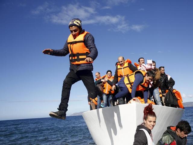 Refugees and migrants jump off a boat as they arrive on the Greek island of Lesbos.(REUTERS) Refugees and migrants jump off a boat as they arrive on the Greek island of Lesbos.(REUTERS)