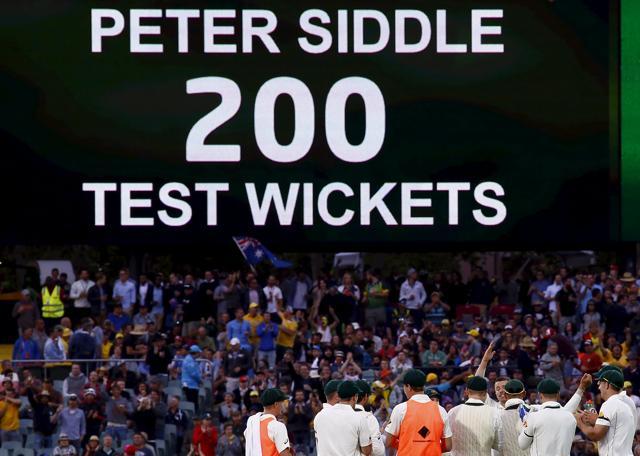 Australia's Peter Siddle (C) is congratulated by teammates and on the scoreboard after taking his 200th Test wicket. (Reuters Photo) Australia's Peter Siddle (C) is congratulated by teammates and on the scoreboard after taking his 200th Test wicket. (Reuters Photo)