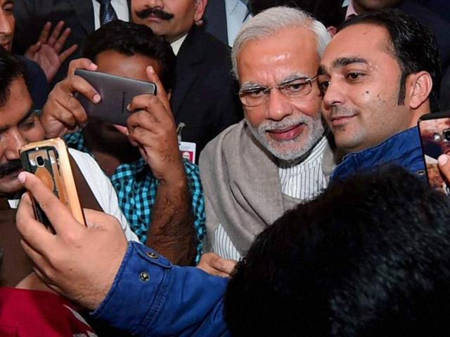 Prime Minister Narendra Modi poses for selfies with journalists during the Diwali Mangal Milan at BJP headquarters in New Delhi on Saturday.(PTI Photo)