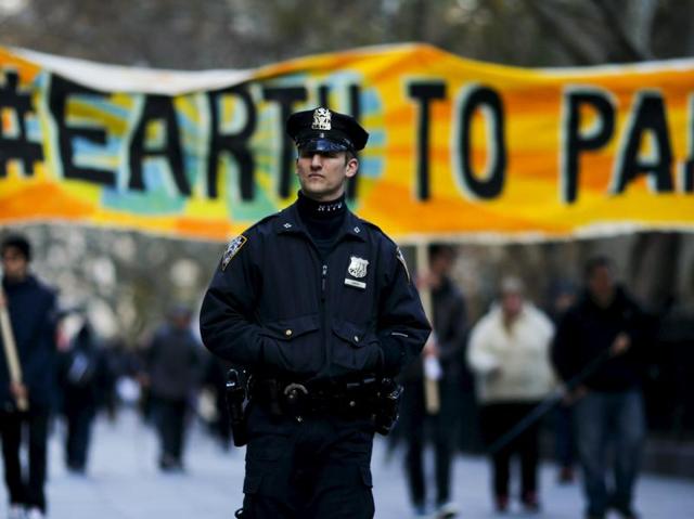 A New York Police officer keeps an eye on protesters while they take part in a protest about climate change around New York City Hall at lower Manhattan, New York. (Reuters Photo) A New York Police officer keeps an eye on protesters while they take part in a protest about climate change around New York City Hall at lower Manhattan, New York. (Reuters Photo)
