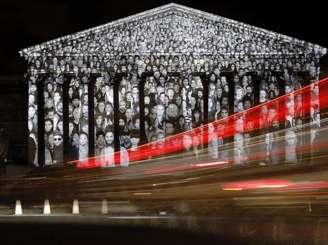 Cars pass by the National Assembly in Paris, where a projection of French artist JR is displayed as part of the 2015 Paris Climate Conference. (AP Photo) Cars pass by the National Assembly in Paris, where a projection of French artist JR is displayed as part of the 2015 Paris Climate Conference. (AP Photo)