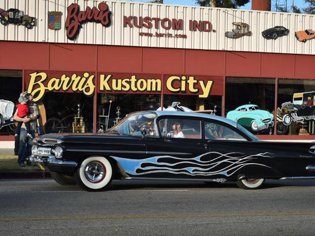 A Hot Rodder drives past the workshop of legendary Hollywood film and television car builder George Barris during a farewell drive-by after his funeral service in North Hollywood, California. (AFP)