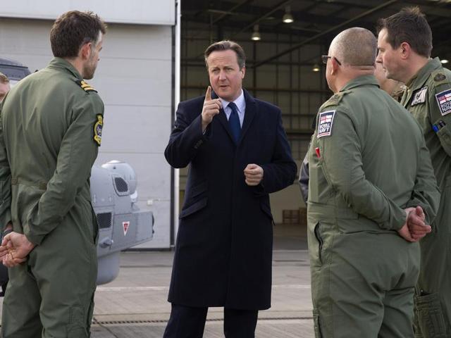 British Prime Minister David Cameron, centre, talks with Royal Navy personnel during his visit to Royal Air Force station RAF Northolt, in west London. (AP Photo) British Prime Minister David Cameron, centre, talks with Royal Navy personnel during his visit to Royal Air Force station RAF Northolt, in west London. (AP Photo)
