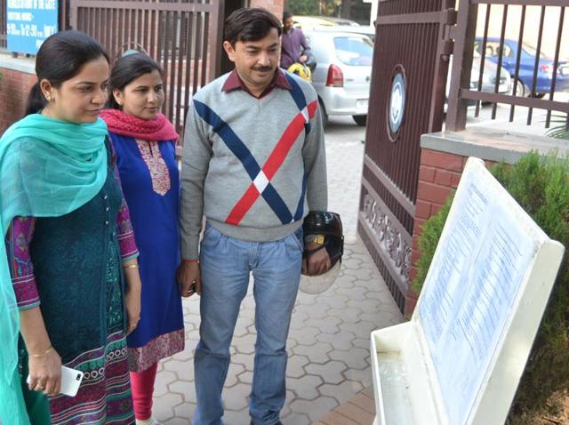 Parents reading details of the admission process at Government Model School, Sector 10, Chandigarh on Monday.(Karun Sharma/HT Photo)
