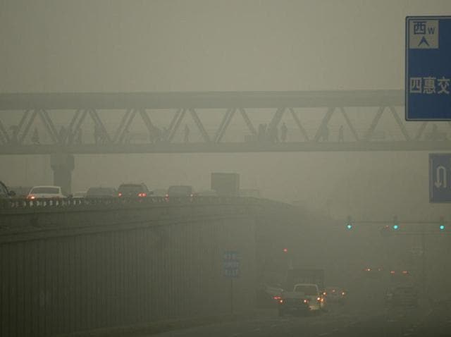 People walk through a overpass in Beijing on December 1, 2015. (AFP) People walk through a overpass in Beijing on December 1, 2015. (AFP)