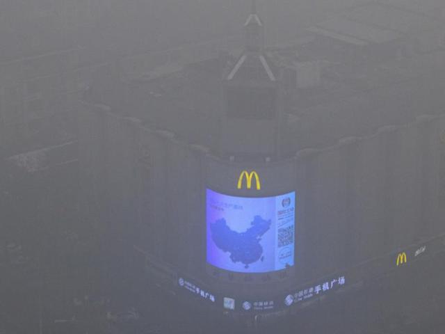 A video display on the side of a building shows a map of China amid heavy pollution and fog in Beijing. (AP Photo)