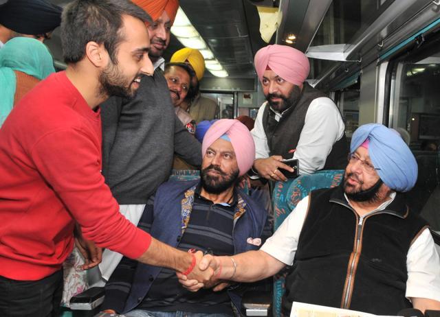 Amritsar MP Capt Amarinder Singh shakes hand with a passenger while travelling to Amritsar from New Delhi . (HT Photo )