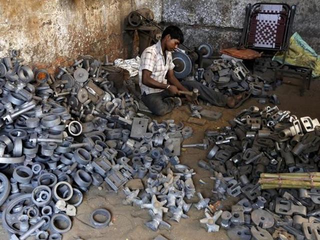 A worker separates casting joints of gearboxes inside a small-scale automobile manufacturing unit in Ahmedabad.(Reuters File Photo)