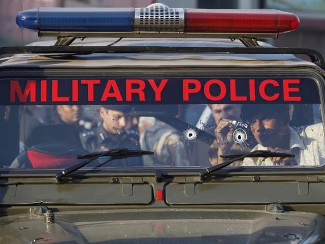 An investigator collects evidence from a bullet-riddled vehicle of military police at the site of the attack in Karachi. (AP) An investigator collects evidence from a bullet-riddled vehicle of military police at the site of the attack in Karachi. (AP)