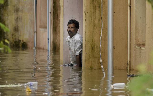 A man awaits rescue outside his water logged house after heavy rains at Kotturpuram area in Chennai. (AP Photo) A man awaits rescue outside his water logged house after heavy rains at Kotturpuram area in Chennai. (AP Photo)