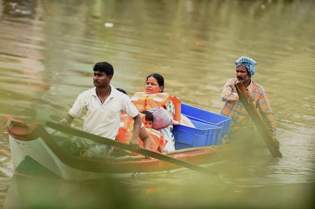 A woman and her kids being shifted from a flooded are in Chennai. (PTI Photo) A woman and her kids being shifted from a flooded are in Chennai. (PTI Photo)